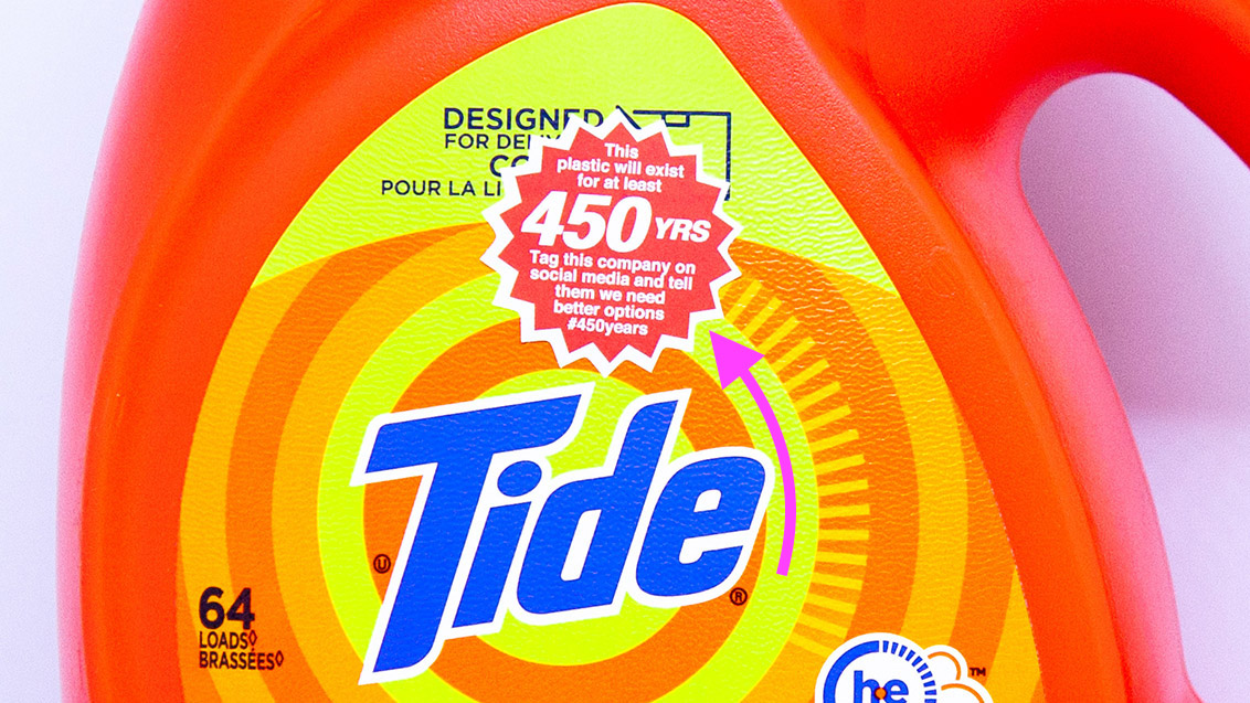 A 1.25 inch sticker on a Tide bottle that says: 'This plastic will exist for at least 450 years. Tag this company on social media and tell them we need better options.'