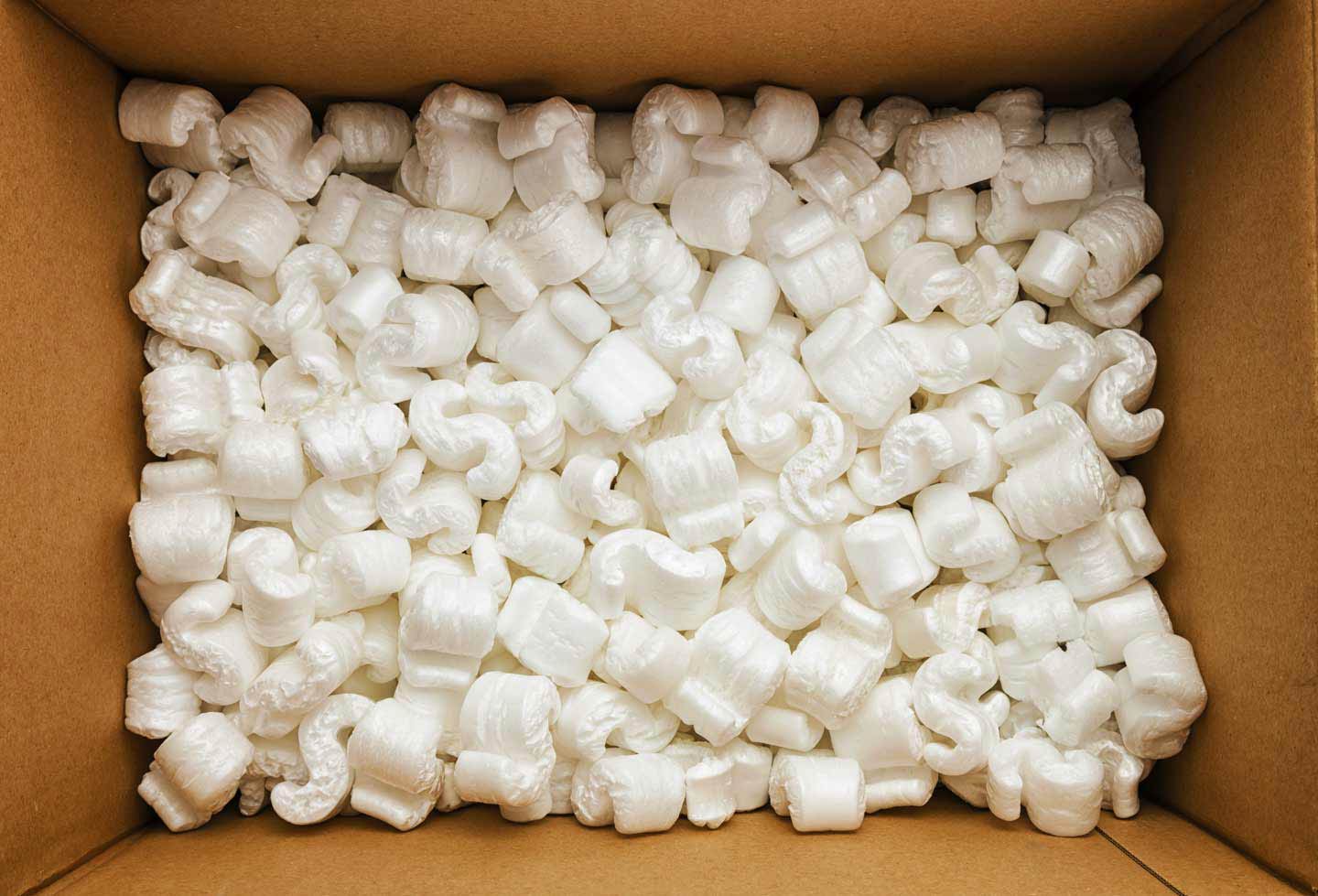 Open cardboard box filled with white styrofoam packing peanuts